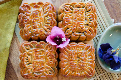 Medium Walnut & Date, Lotus & Yolk, Red Bean, Pineapple Mooncakes on bamboo