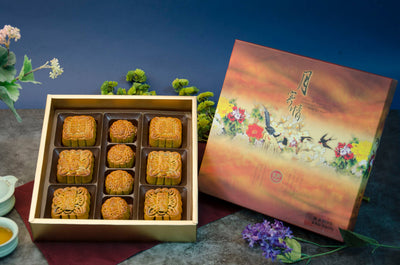 An assorted gift box of mooncakes with six medium and four small mooncakes, displayed in a decorative box with floral  designs.