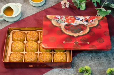 A Gift Box of 12 Assorted Small Mooncakes, with 6 Different Flavors. In a red decorative tin on red fabric.