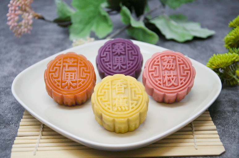 Mulberry, Banana, Lychee, Mango Mooncakes on a white plate on bamboo