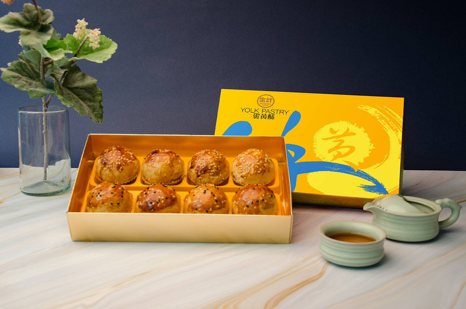 8 pcs Salted Egg Yolk Pastry Box, with decorative golden box behind and small tea pot and tea cup beside.
